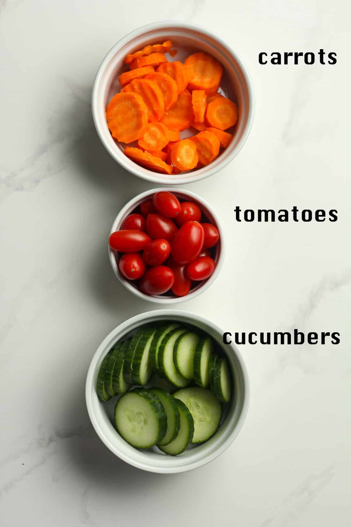 Bowls of carrots, tomatoes and cucumbers.