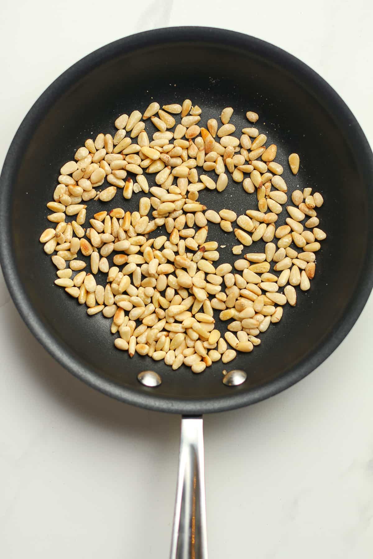 The toasted pine nuts in a pan.