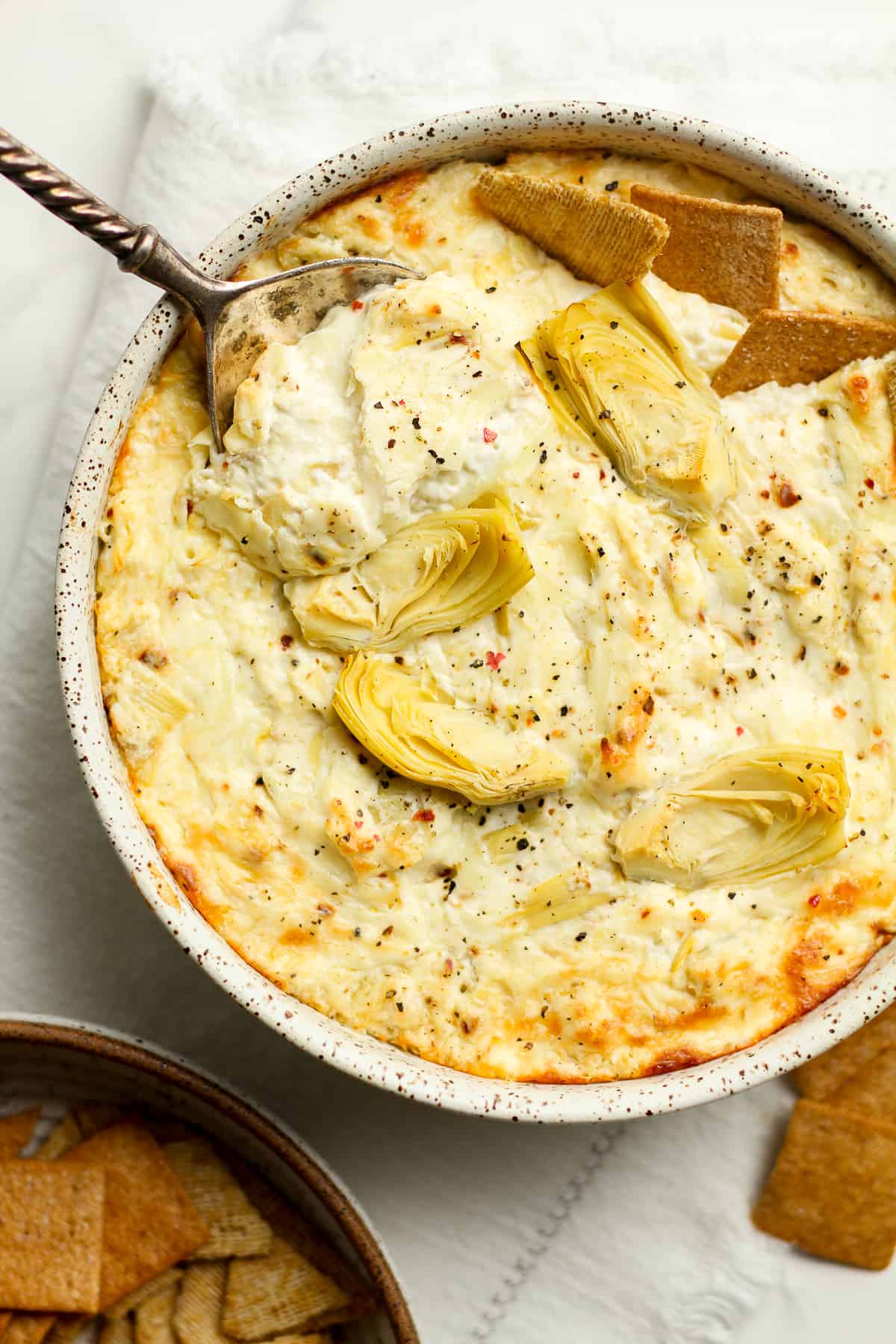 Closeup of the artichoke dip with a spoon.