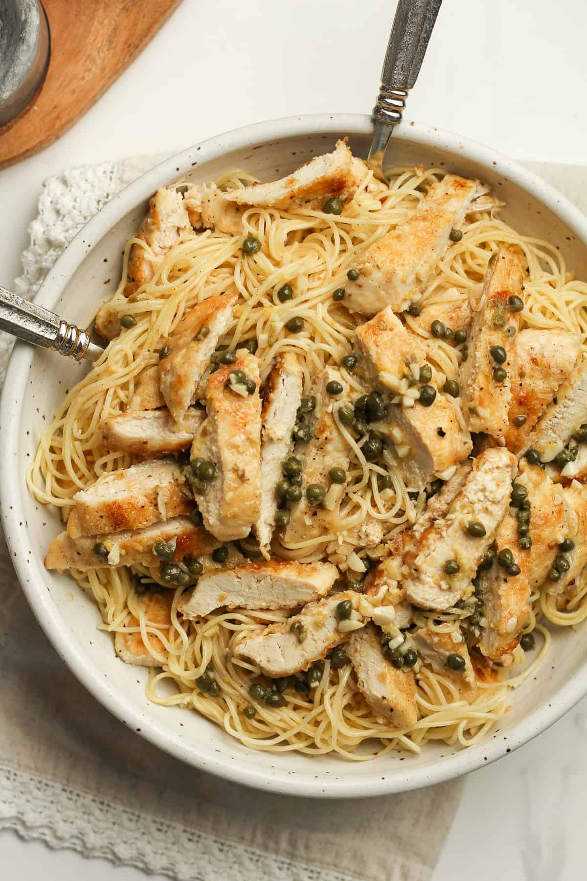 Closeup on a bowl of chicken piccata with pasta.
