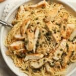 A bowl of pasta with chicken piccata.