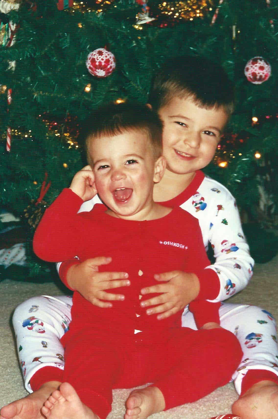 Josh and Zach in their Christmas pjs, by the tree.