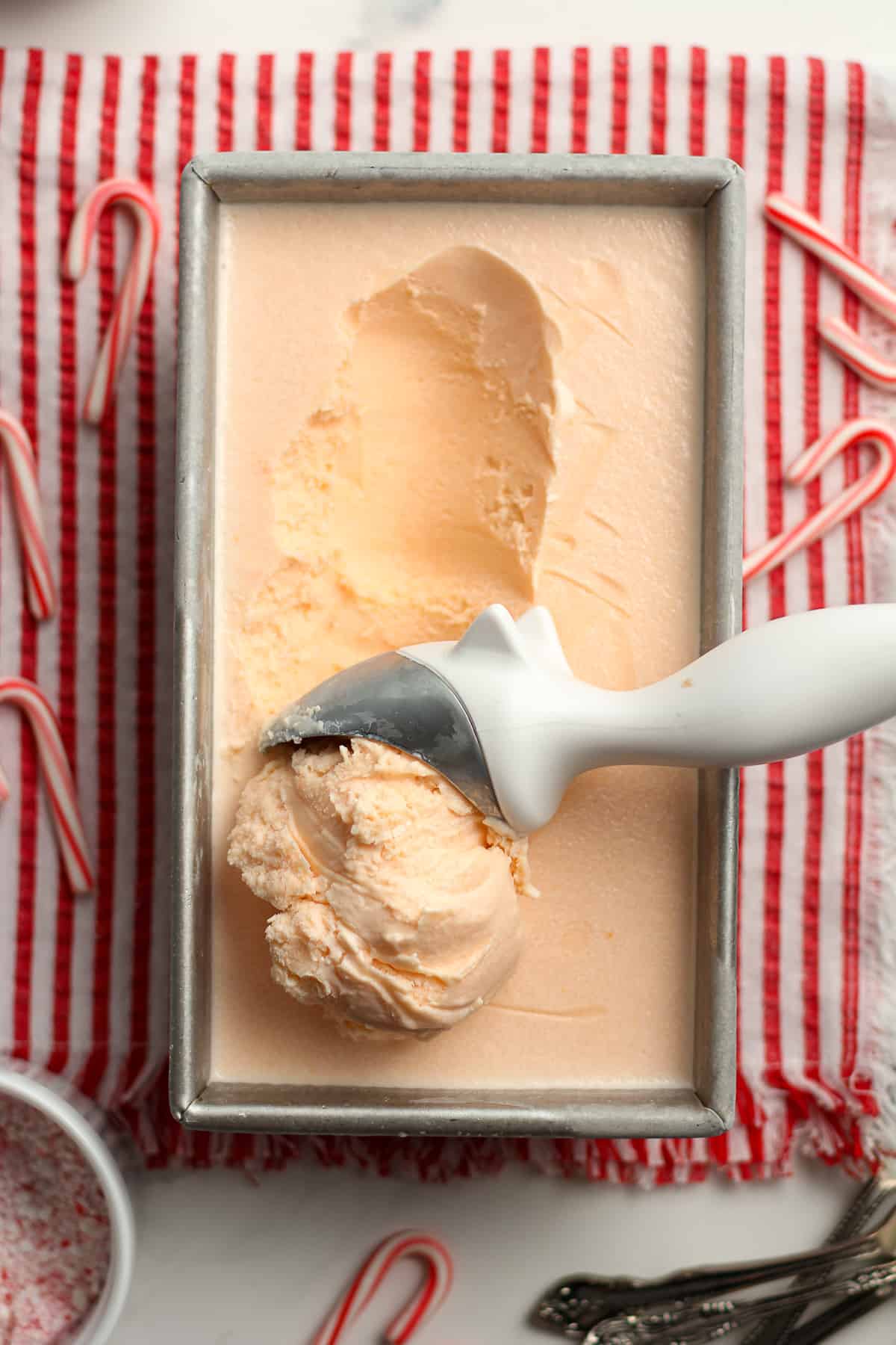 A pan of homemade peppermint ice cream with a scoop.