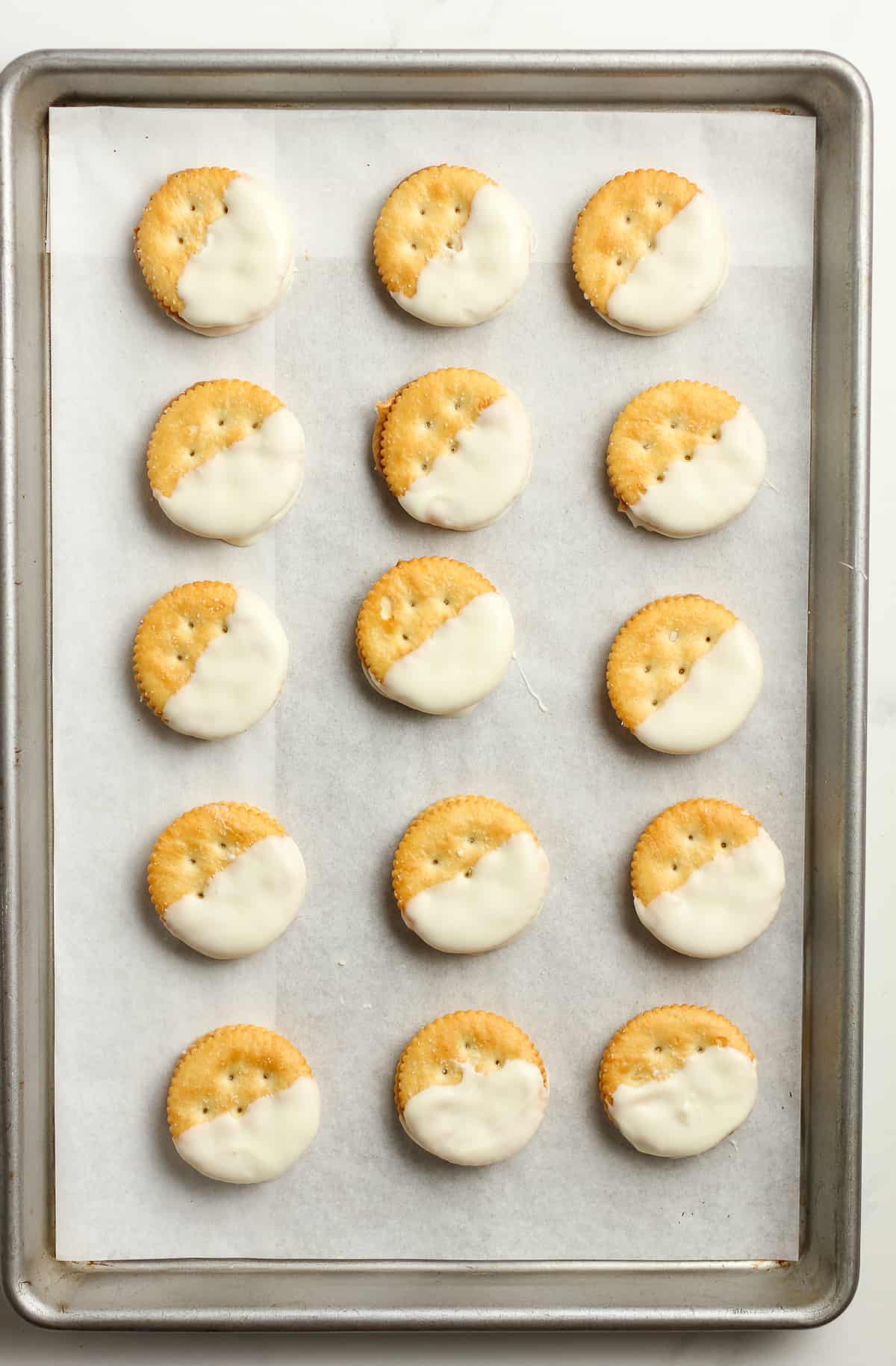 A pan of cookies with half covered in white chocolate.