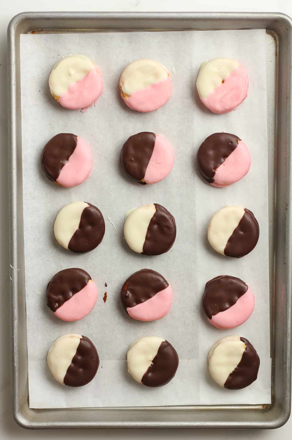 A pan of pink, white, and black cookies.