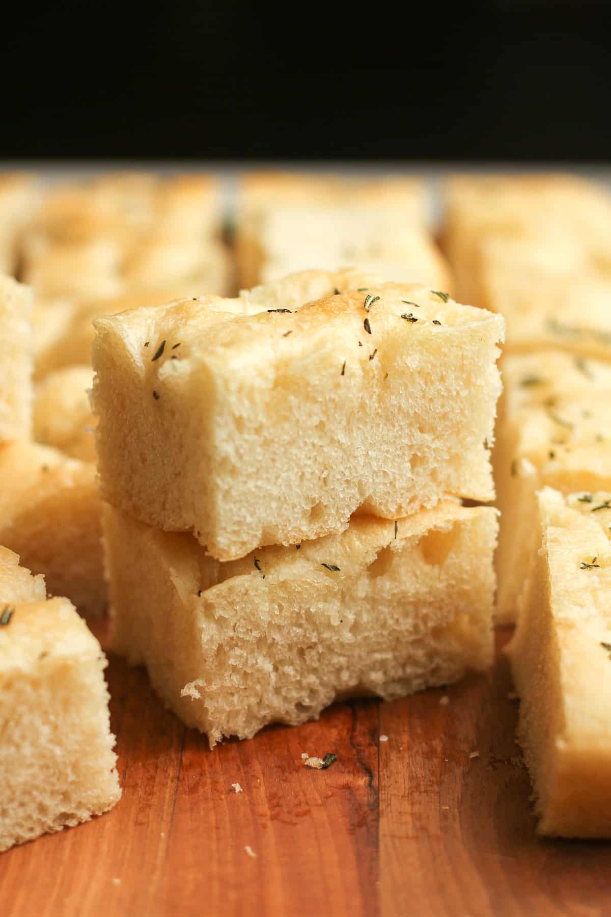 Side view of some stacked rosemary focaccia bread.