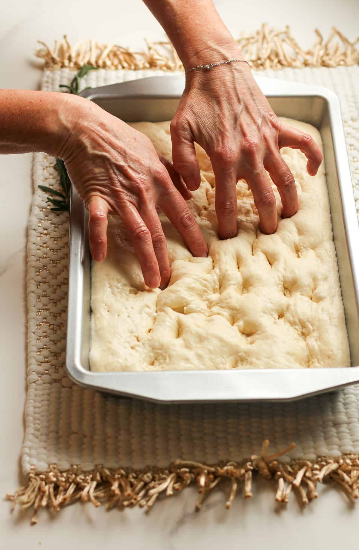 My hands poking holes in the bread dough.