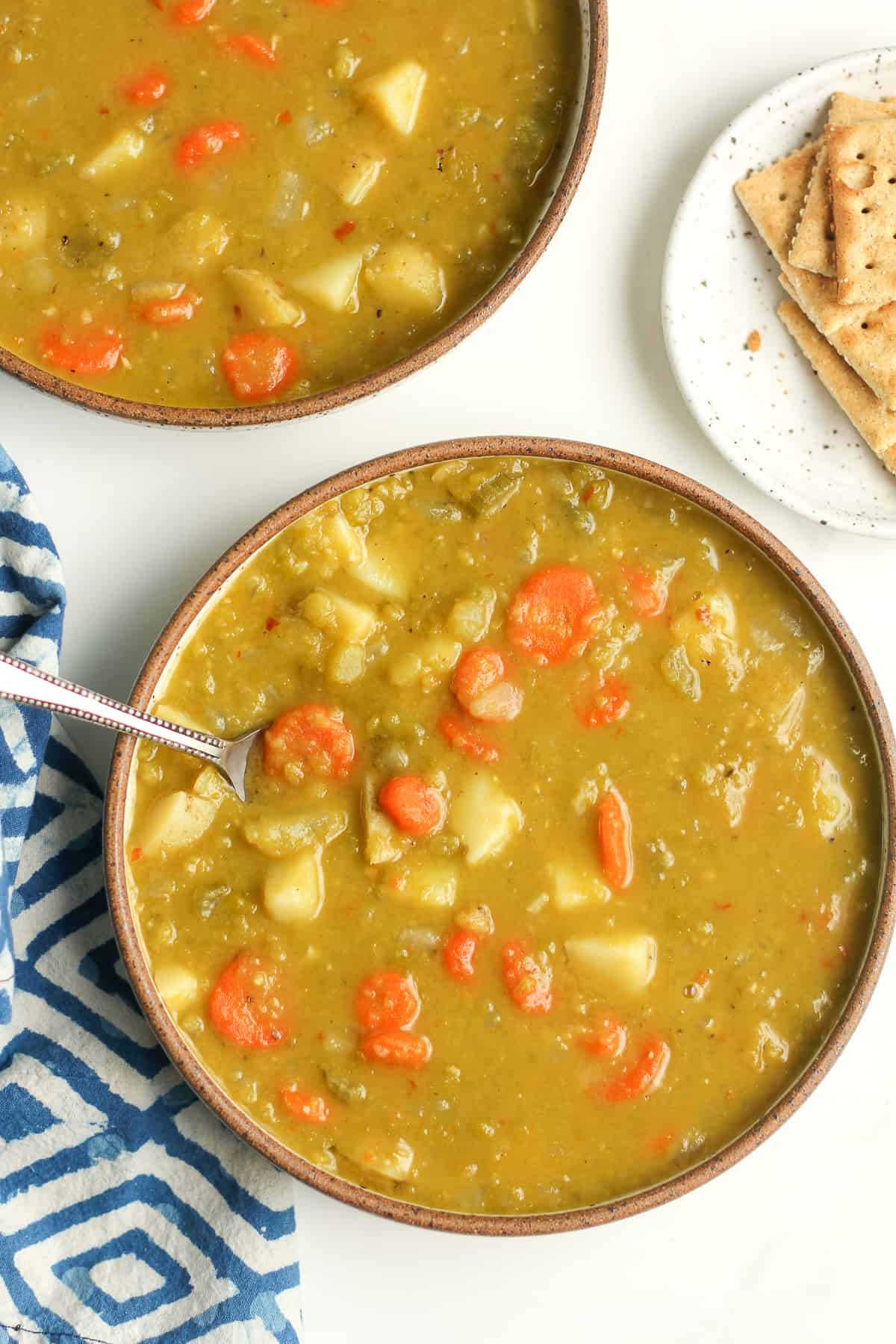 Two bowls of soup with spoons.