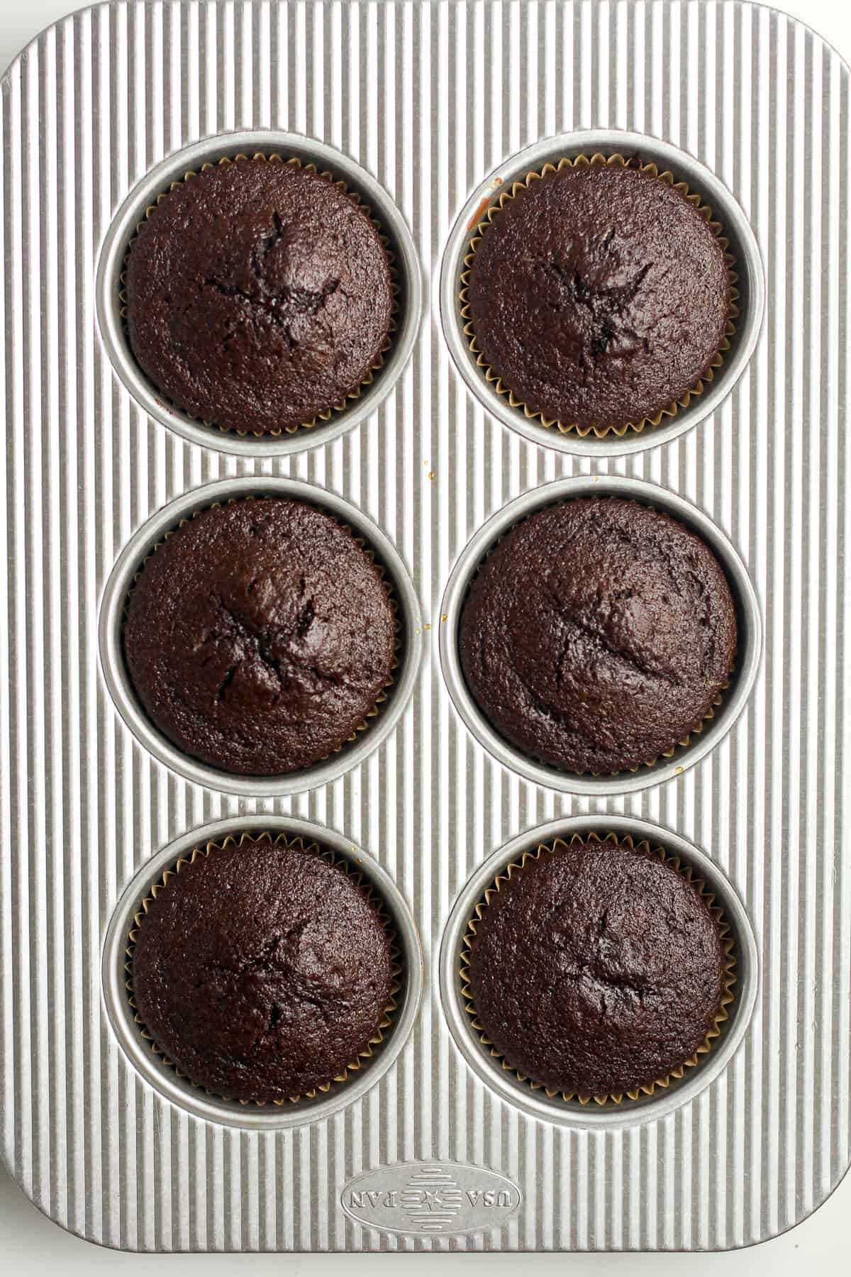 The just baked cupcakes in the jumbo muffin tins.