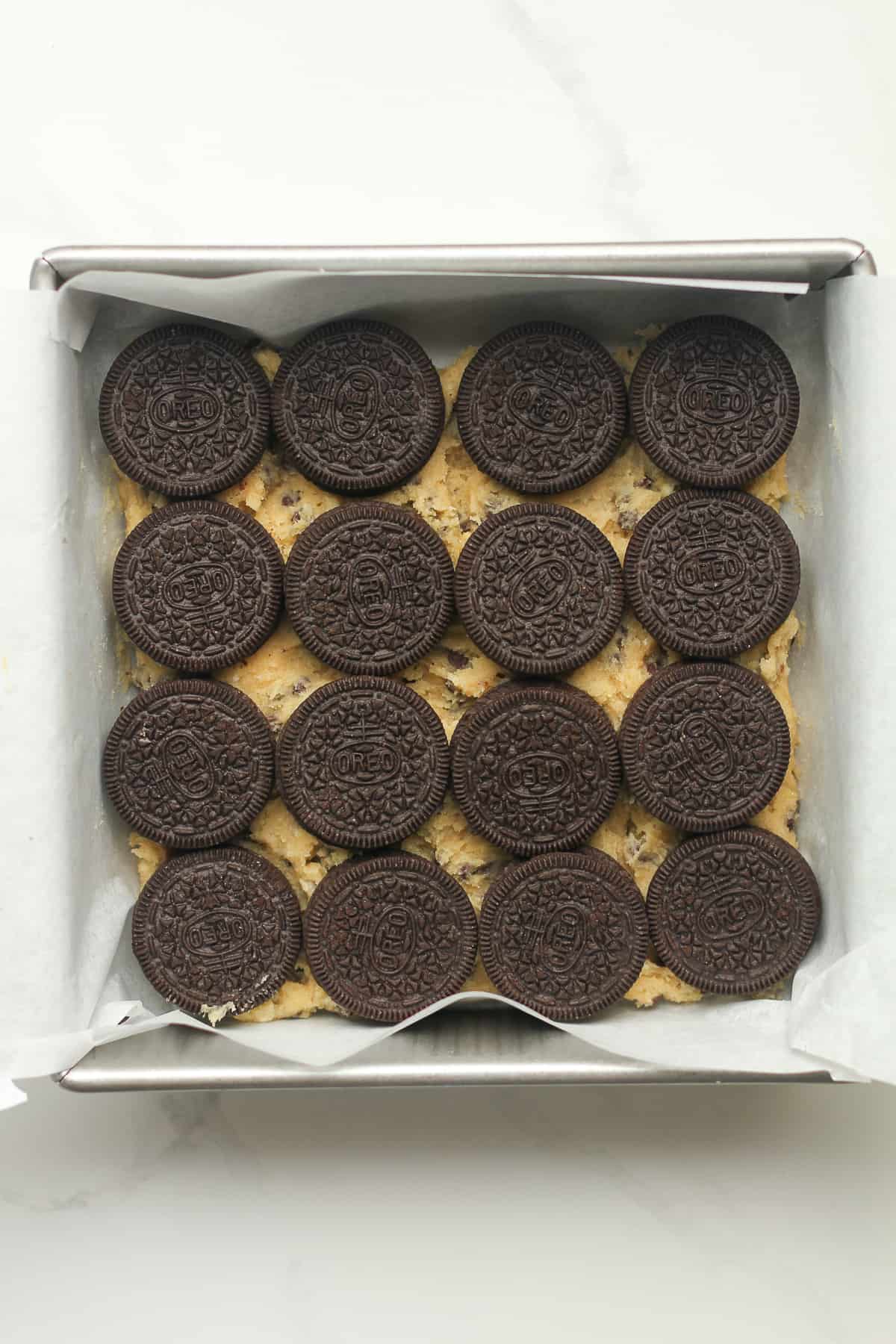 A square pan with the Oreo cookie layer (layer 2) on top.