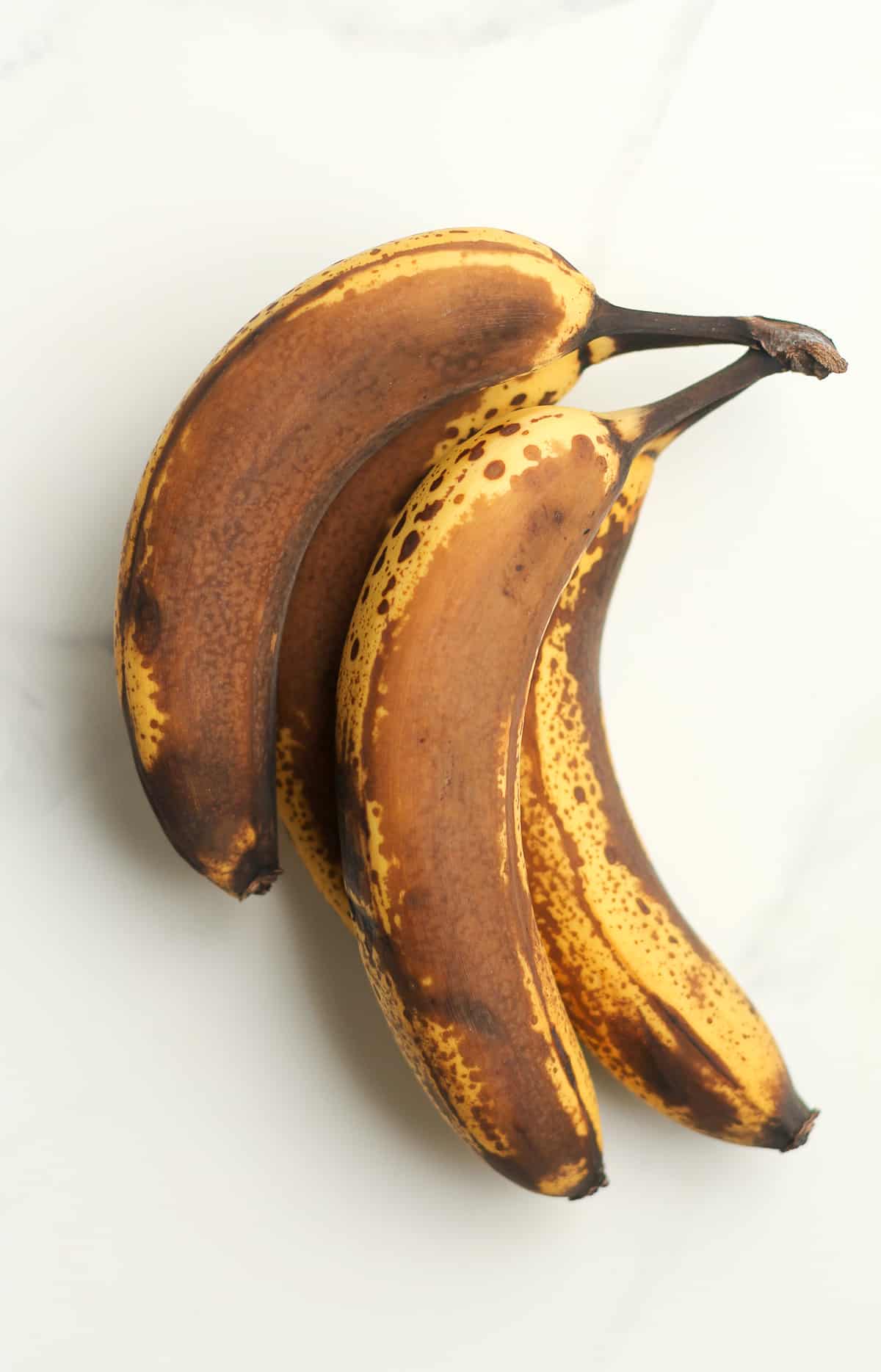 Some over-ripe bananas on a white background.