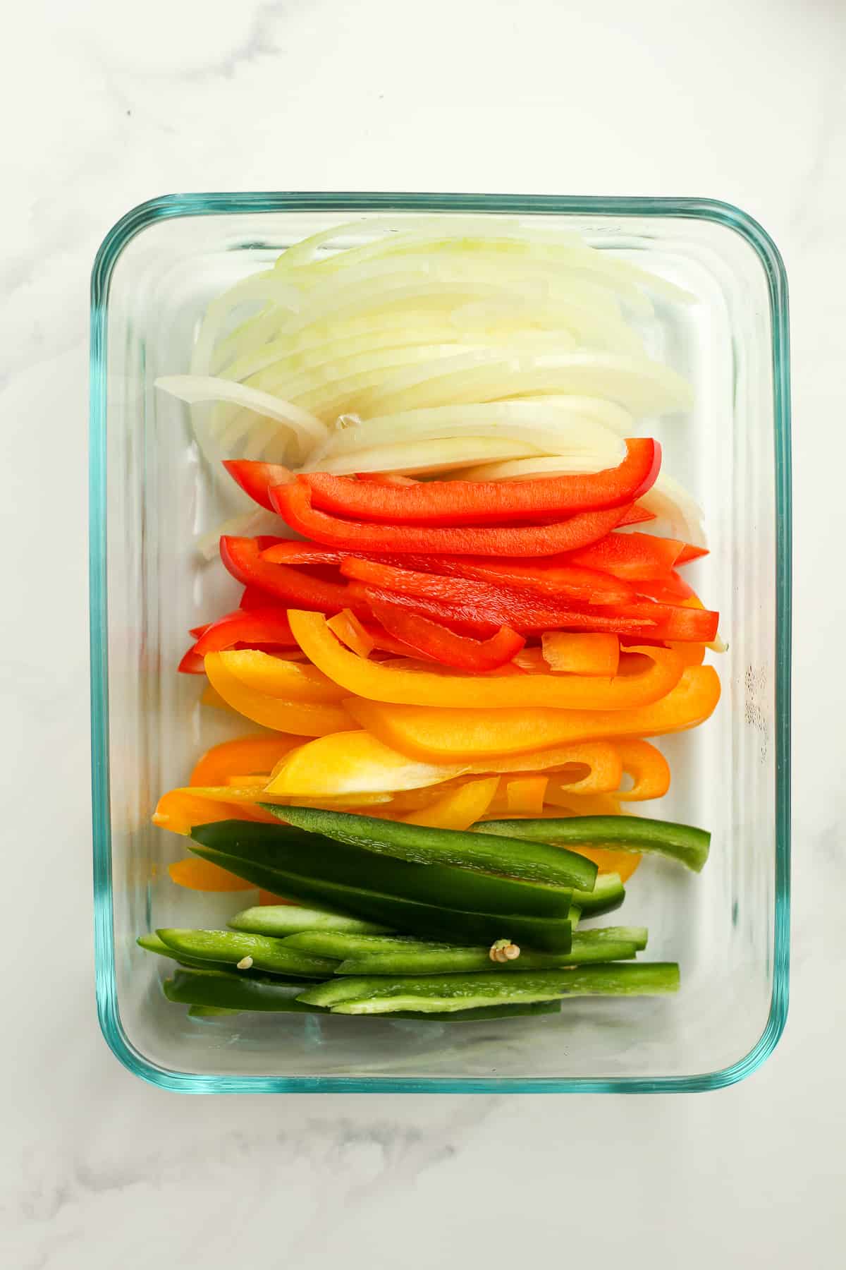 A bowl of sliced peppers and onions.