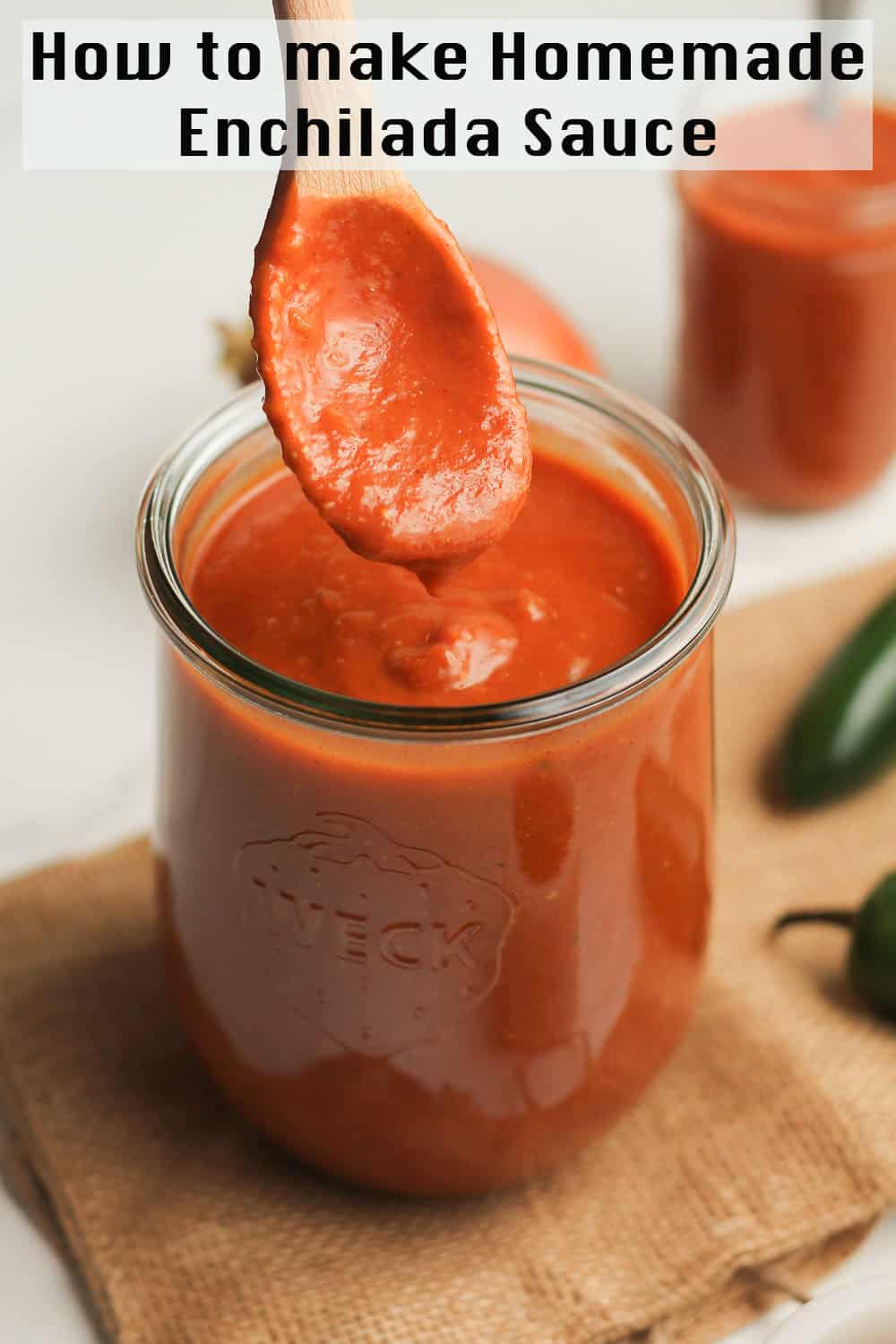 A spoonful of homemade enchilada sauce over a jar.