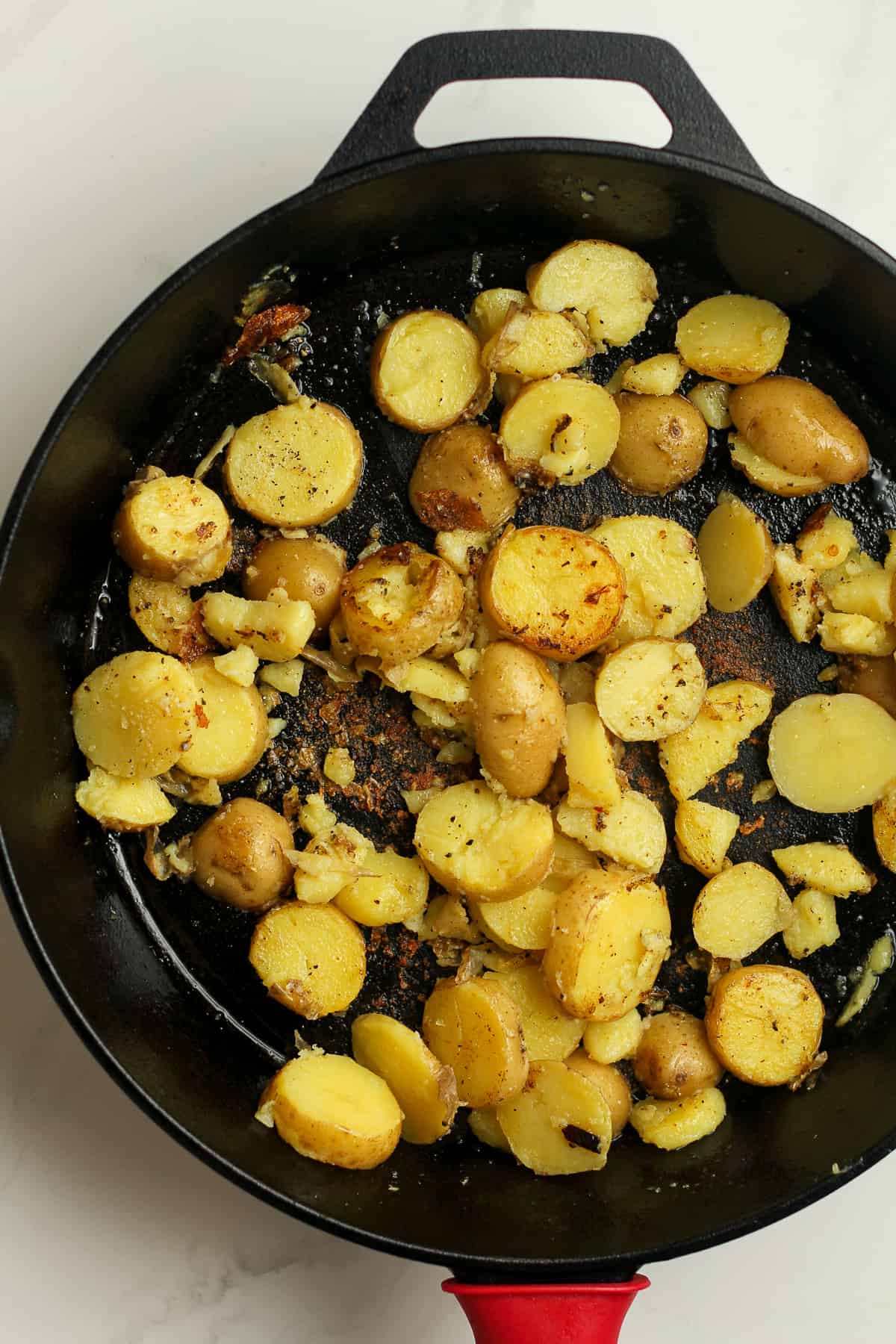The skillet with the cooked yellow potatoes.