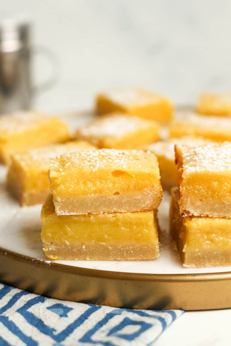 A tray of stacked lemon shortbread bars, some stacked in front.