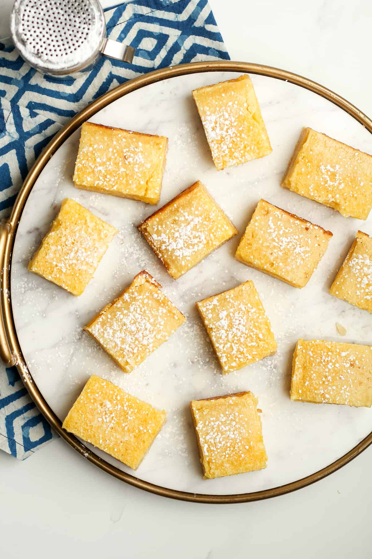 A round tray of lemon shortbread bars with powdered sugar on top.