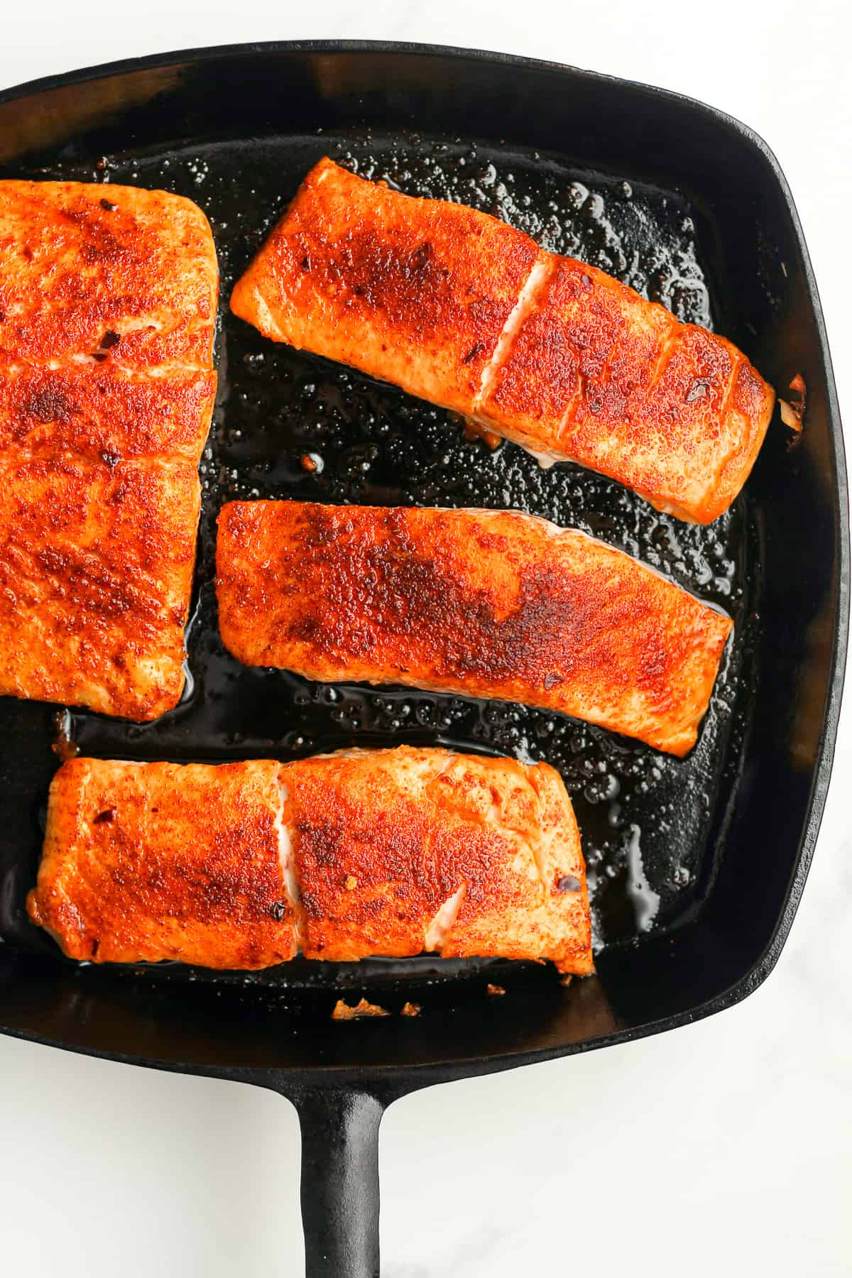 A skillet of blackened salmon.