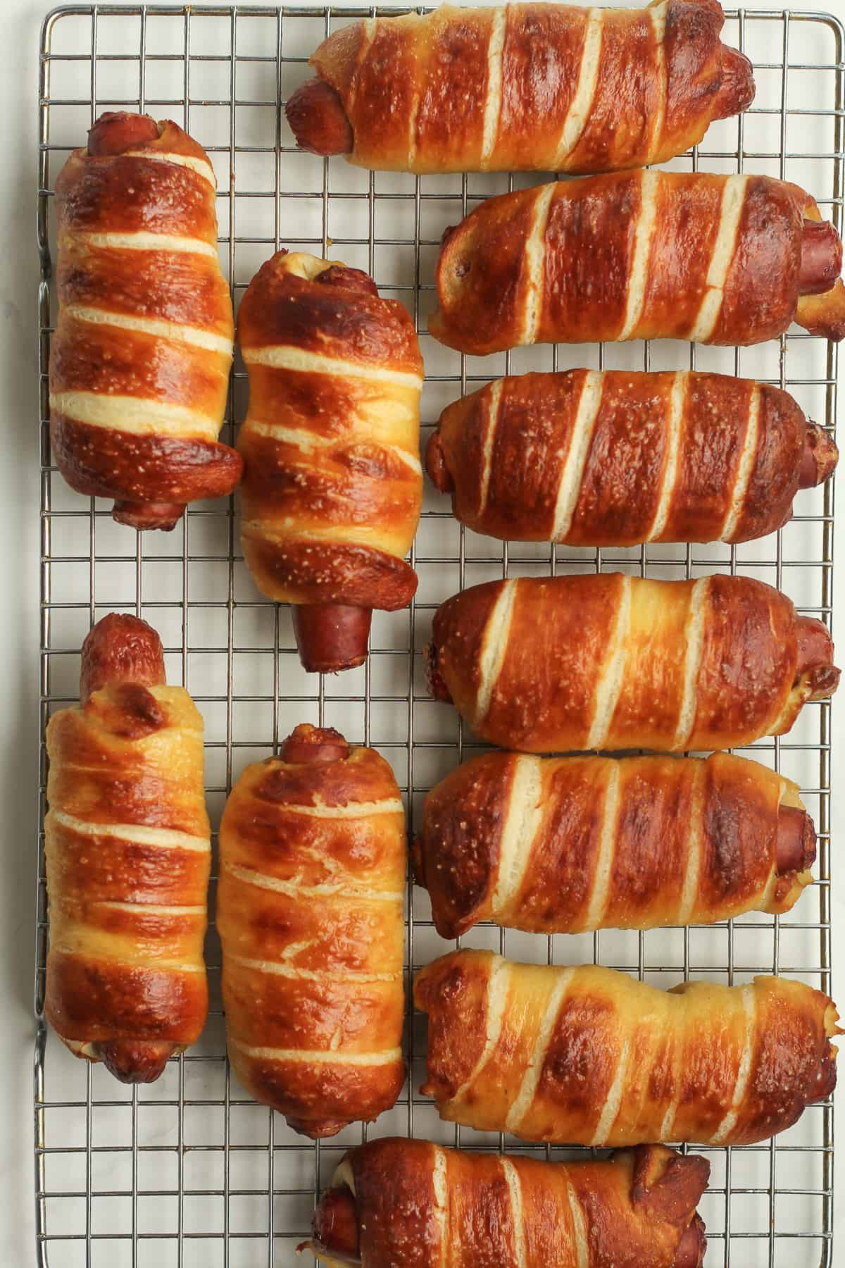 The pretzel dogs cooling on a rack.