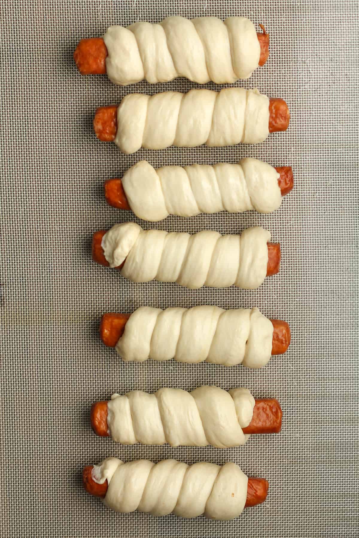The pretzel dogs after wrapping in the dough, before boiling.
