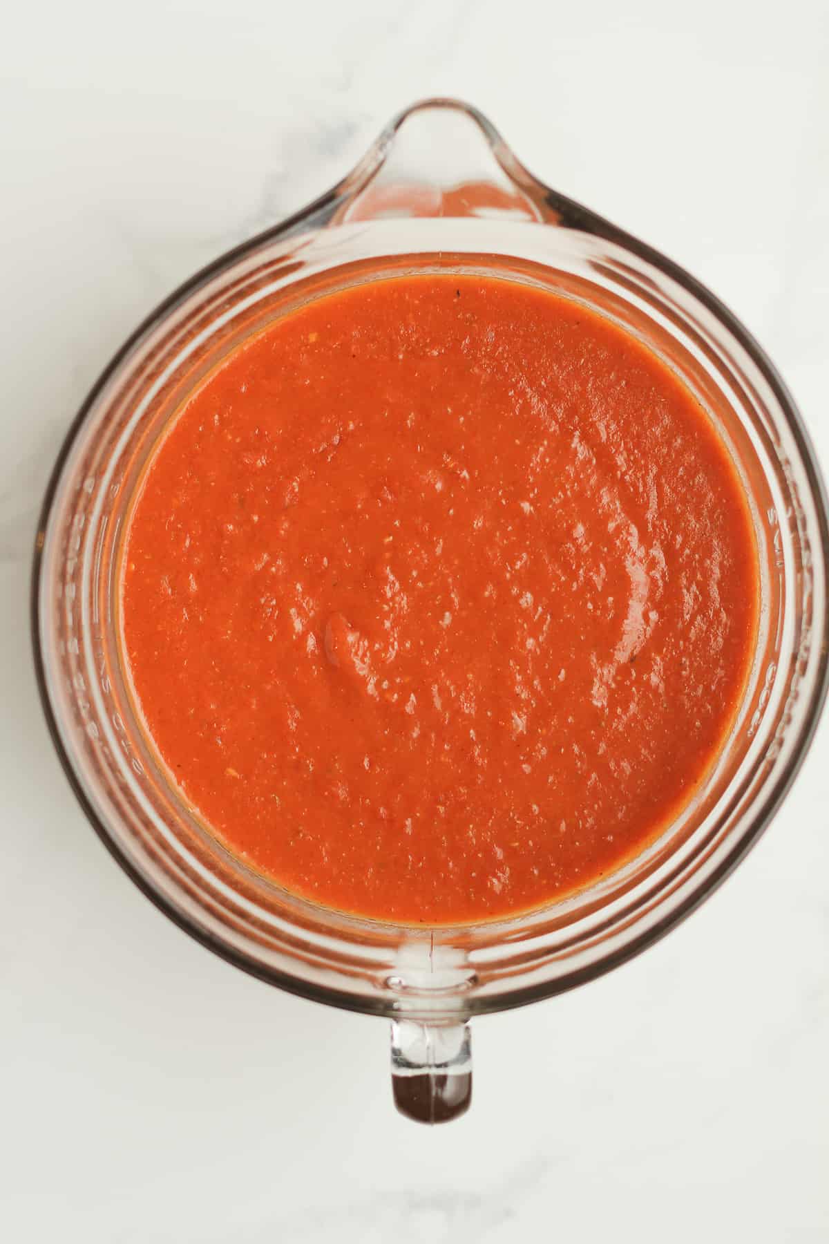 Overhead shot of a measuring cup of sauce.