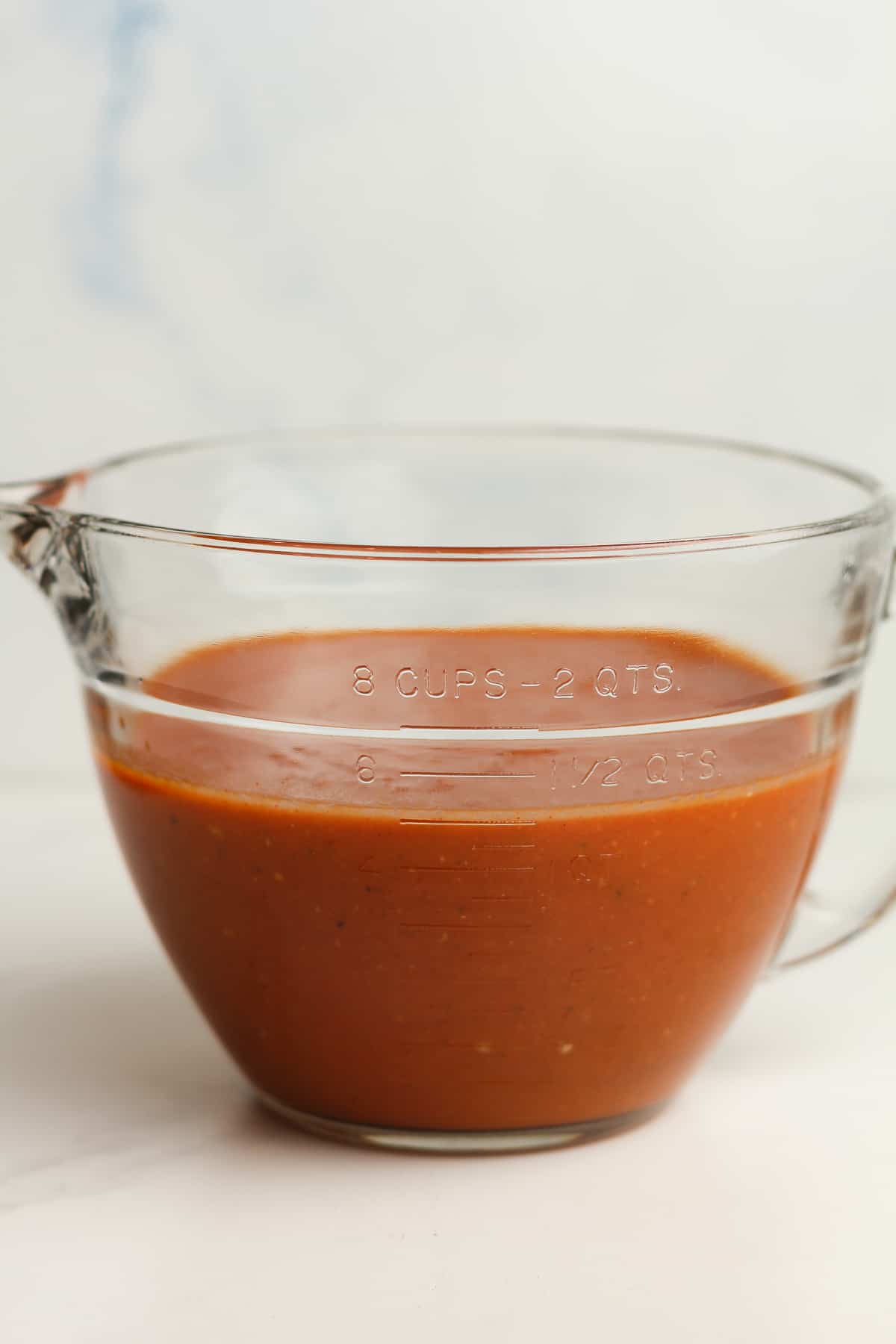 Side view of a measuring cup of sauce, showing five cups.