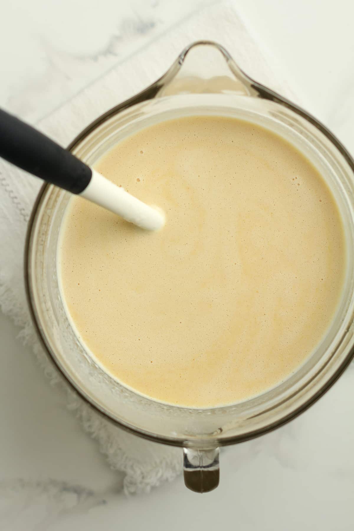 Overhead shot of a large measuring cup of liquid ice cream mixture.