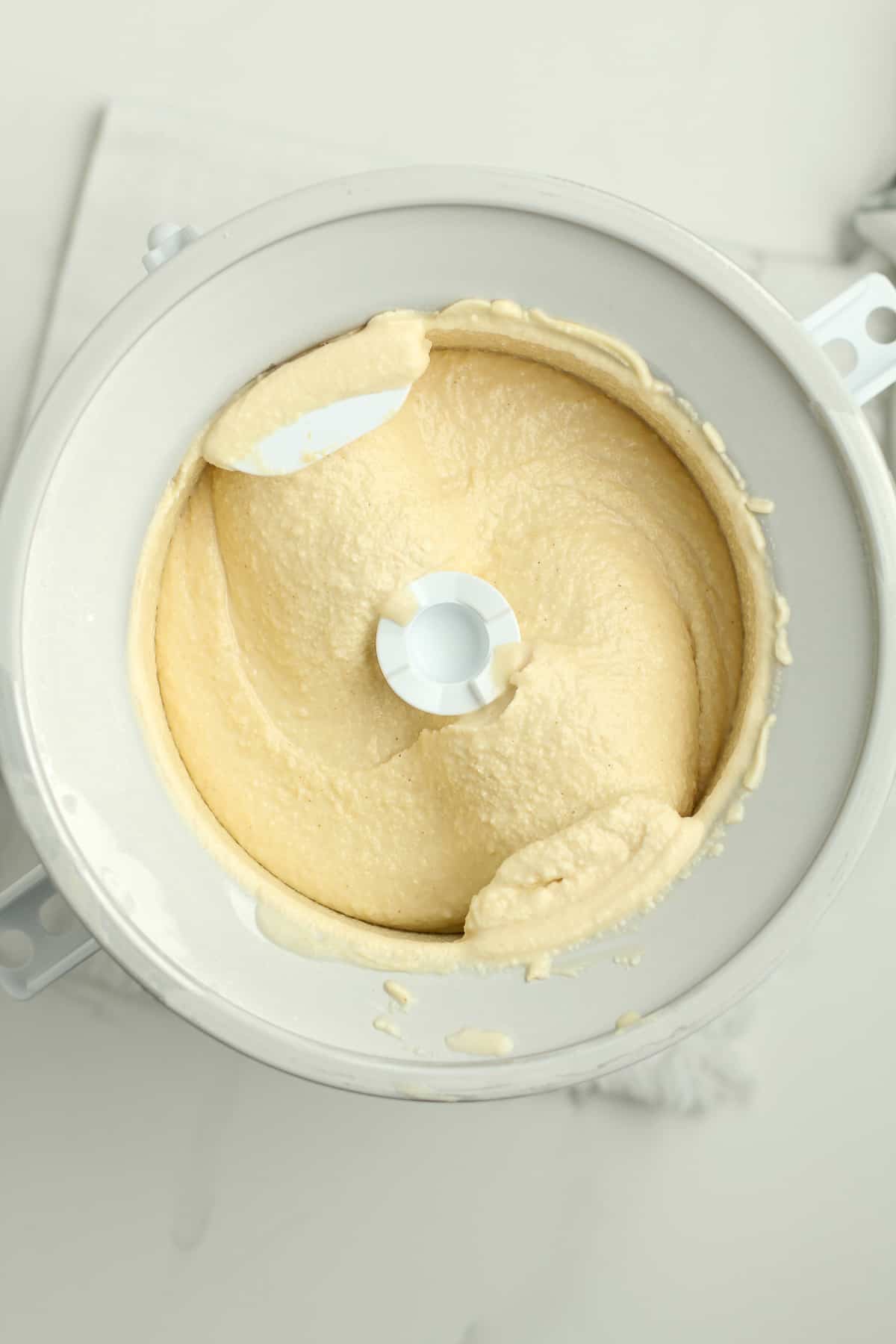 A KitchenAid ice cream churner with peanut butter ice cream inside.