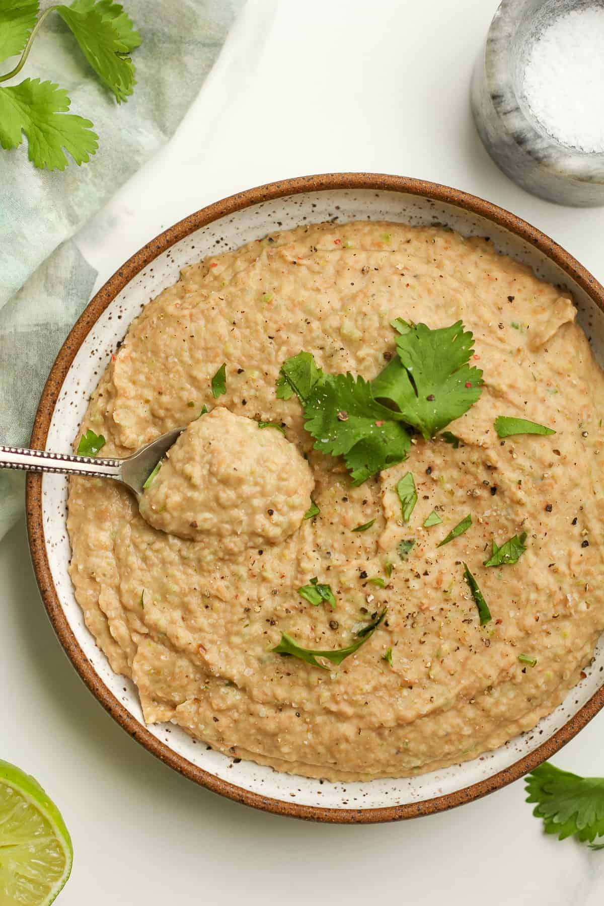 A spoonful of refried beans in a bowl of beans.