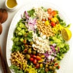 A platter of Mediterranean chopped salad, with a lemon wedge.