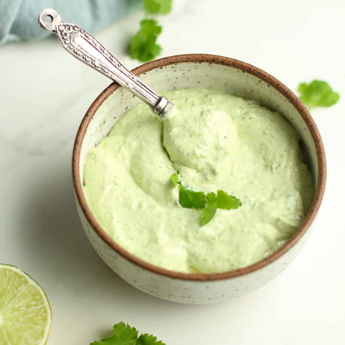 A bowl with Avocado Crema and a spoon on top.