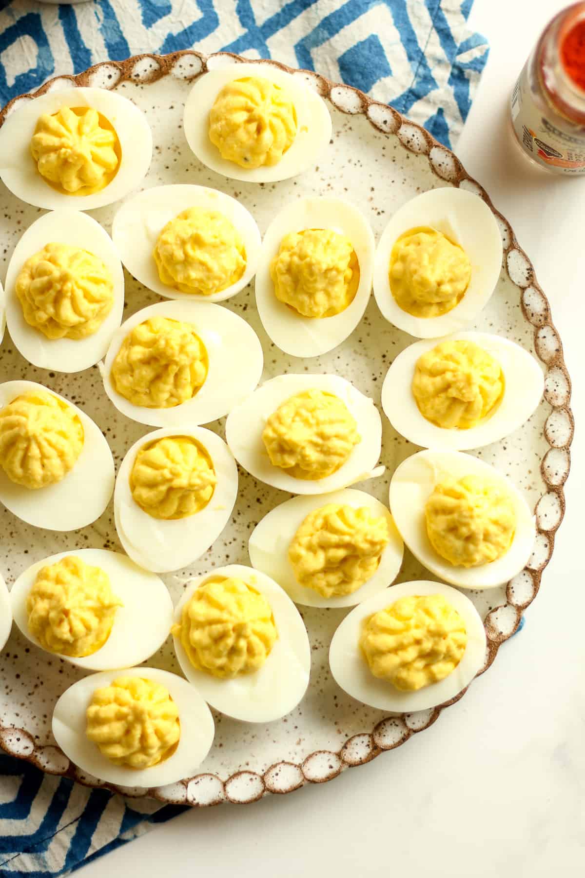 The deviled eggs on a plate before paprika topping.
