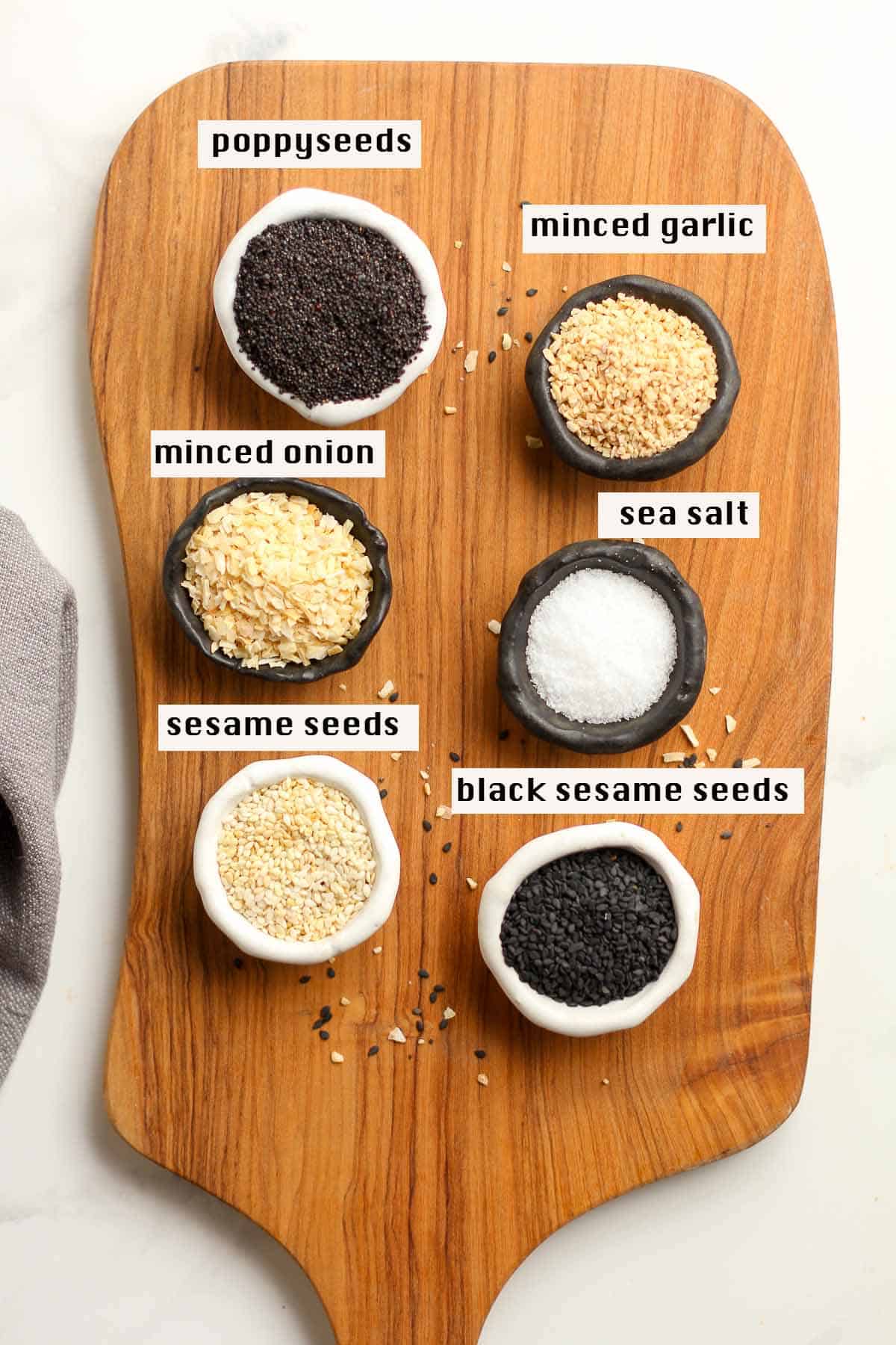 A board with little bowls of the ingredients for Everything Bagel Seasoning.