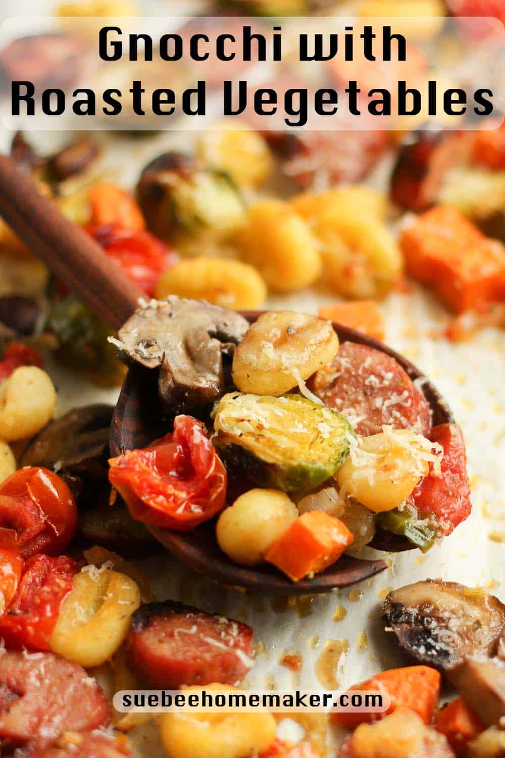 A sheet pan of gnocchi and roasted veggies and a spoonful of the veggies on top.