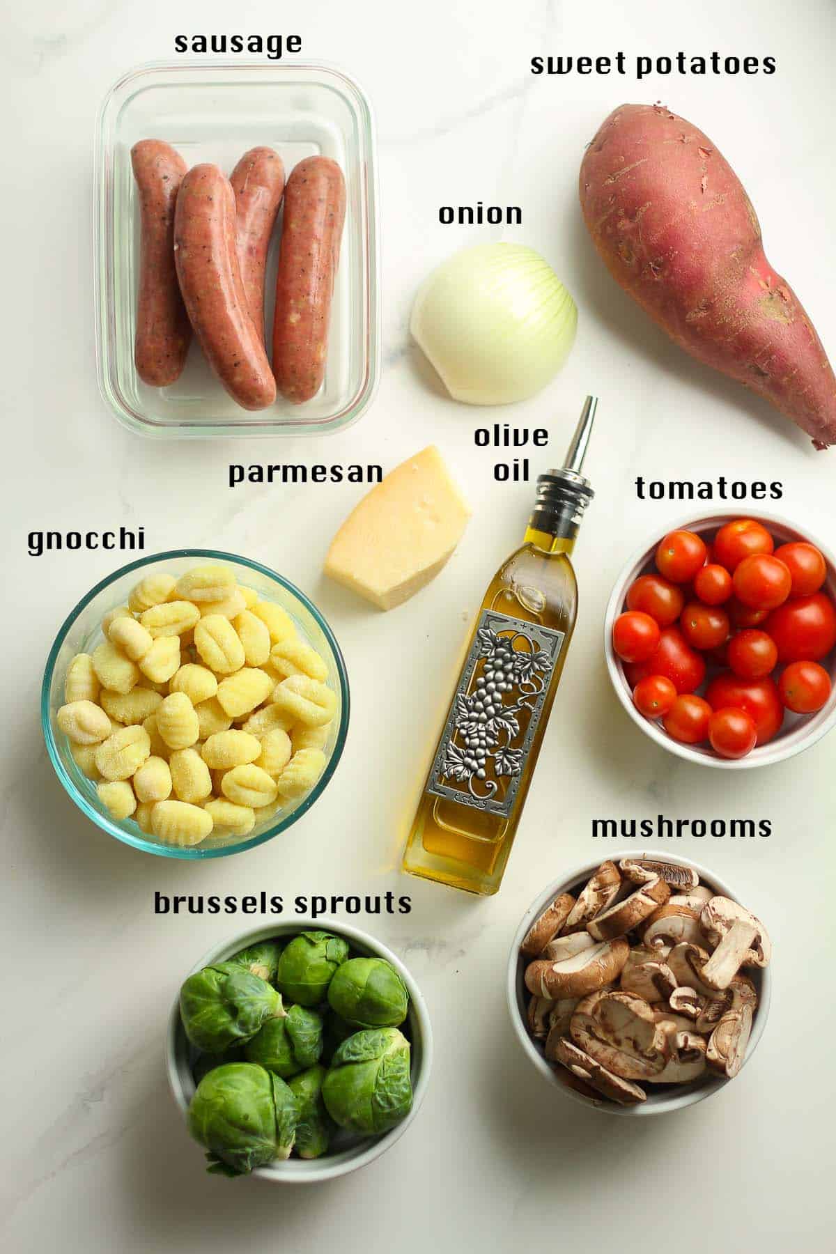 The ingredients, labeled, for the gnocchi and vegetable bake, including sausage, onion, mushrooms, etc.