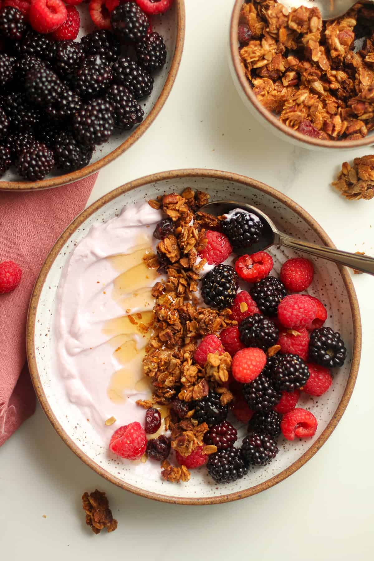 Closeup on a bowl of fruit, granola, and yogurt, with a drizzle of honey.