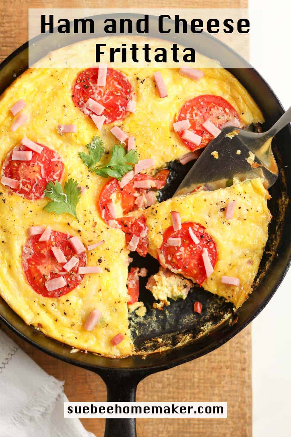 A partial baked ham and cheese frittata with tomato slices on top.