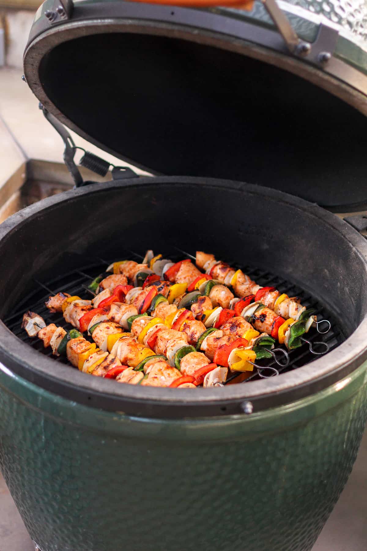 A shot of the Big Green Egg with the kabobs on the grill.