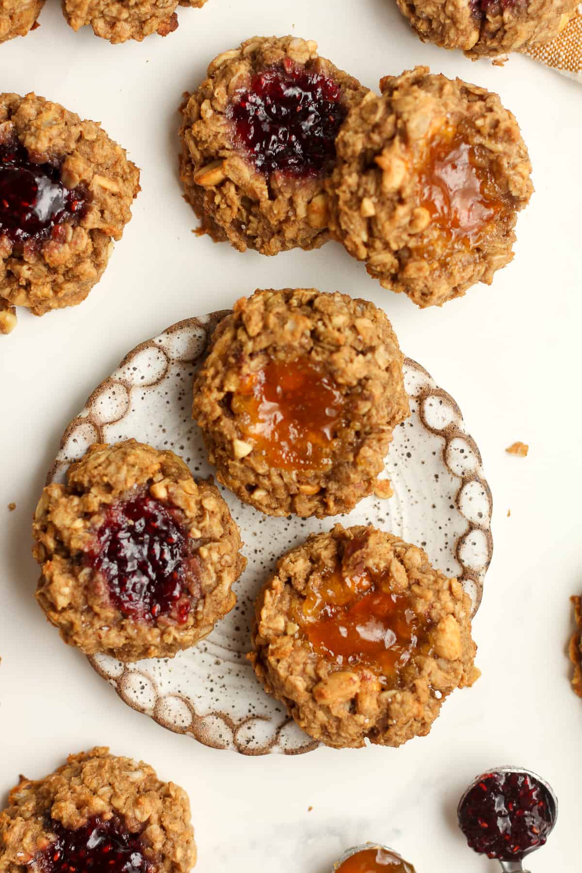 A plate of three cookies with others surrounding it.