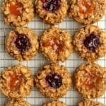 Peanut butter oatmeal breakfast cookies with jam centers on a cooling rack.