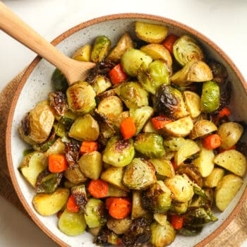 A bowl of roasted potatoes, brussels, and carrots.