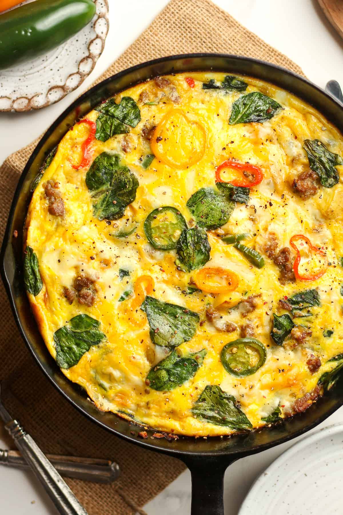 Closeup on a sausage frittata with spinach and other veggies.