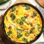 A cast iron skillet of the sausage frittata with veggies.