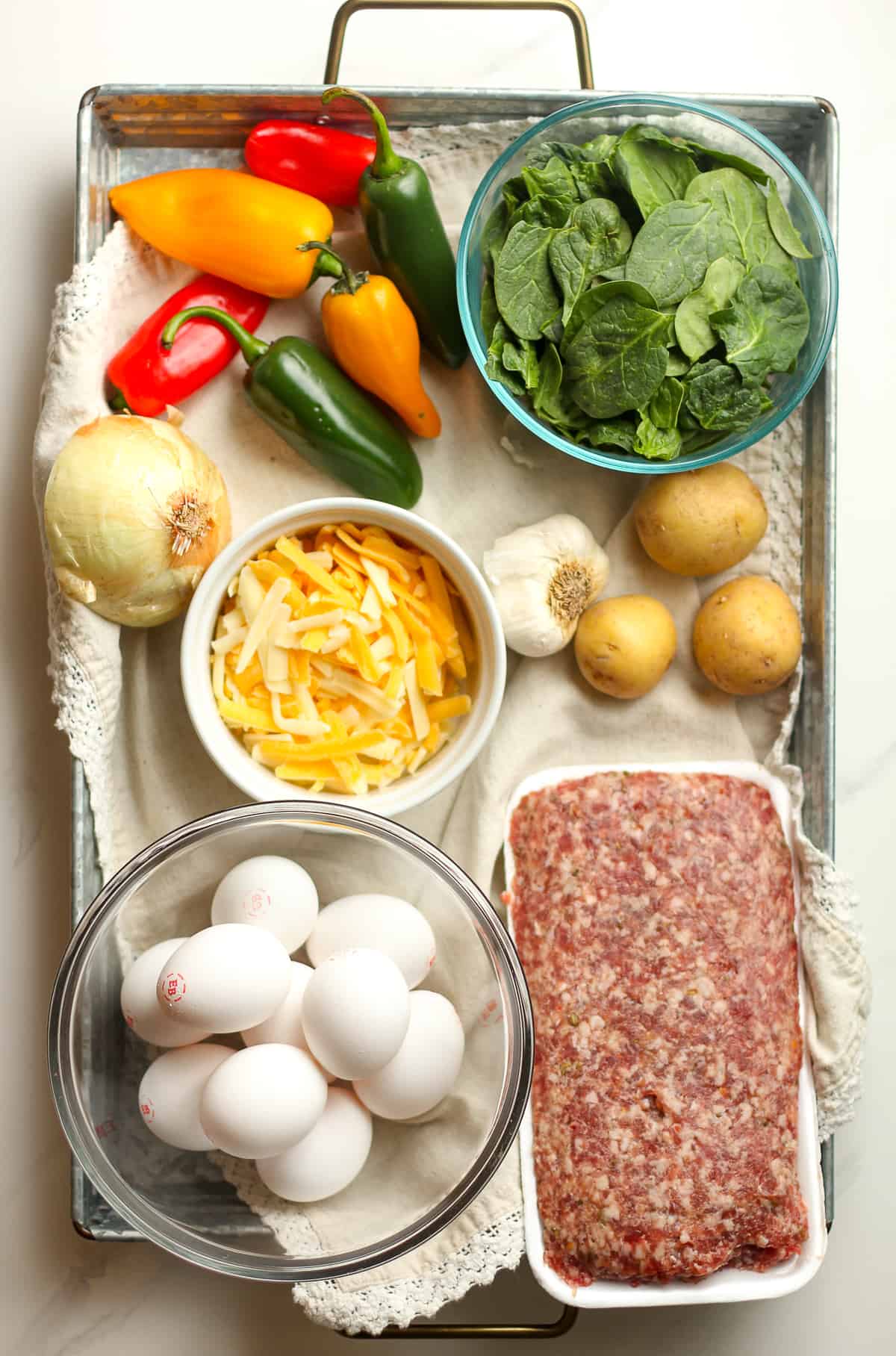 A tray of the ingredients for the sausage and spinach frittata.