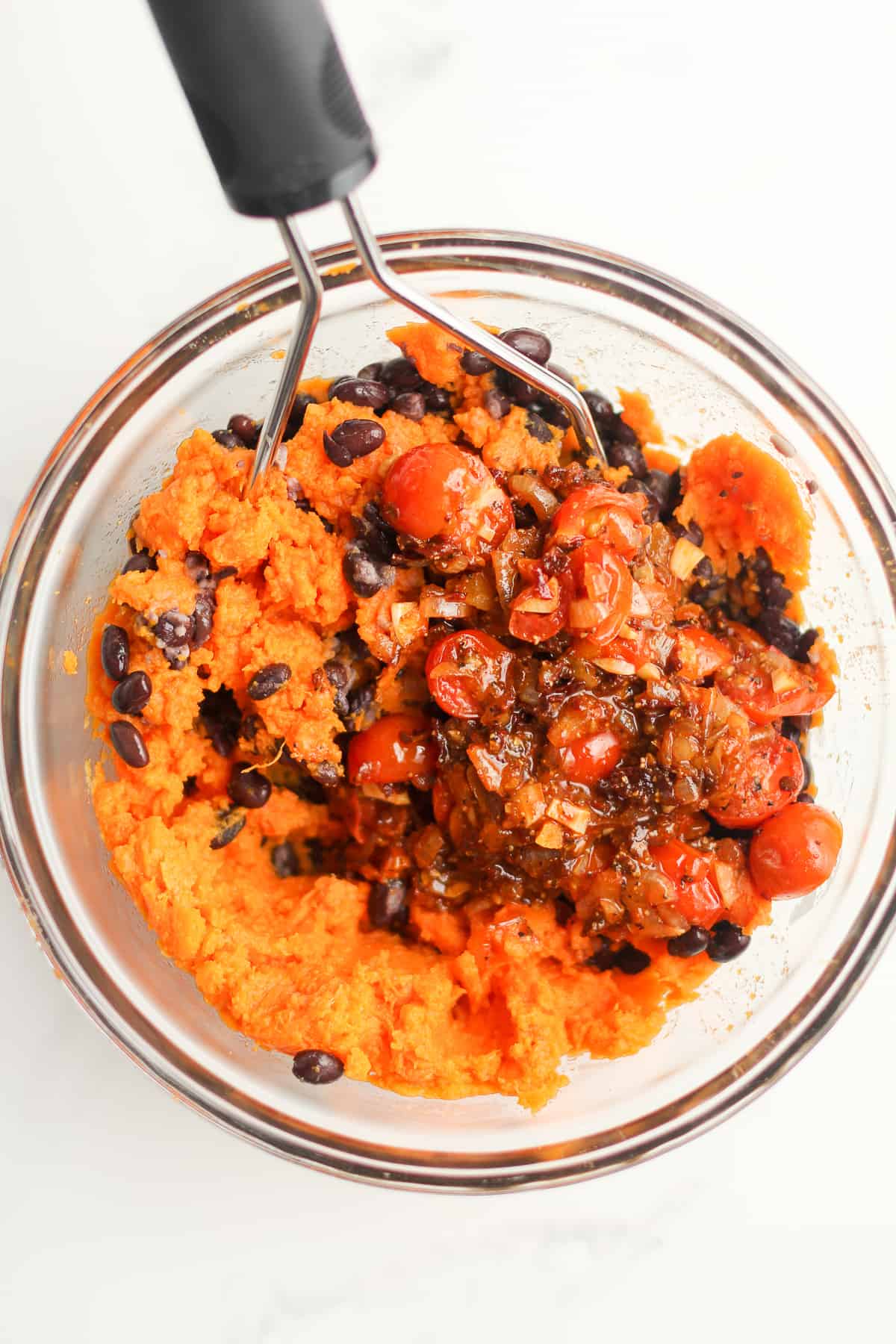 A bowl of the sweet potato, bean, and veggie mixture - with a potato mixture.