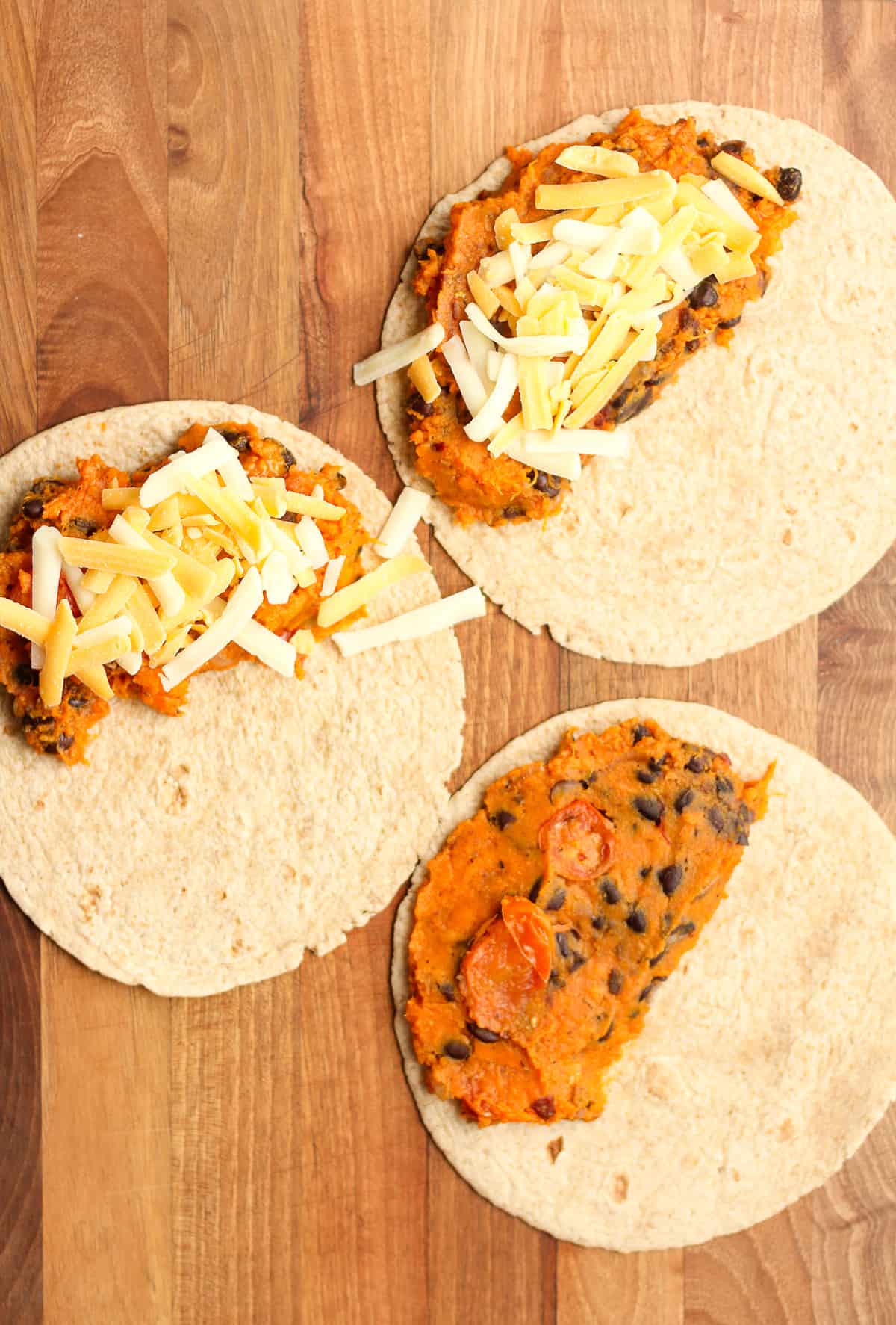 Three tortillas with the sweet potato mixture and cheese.