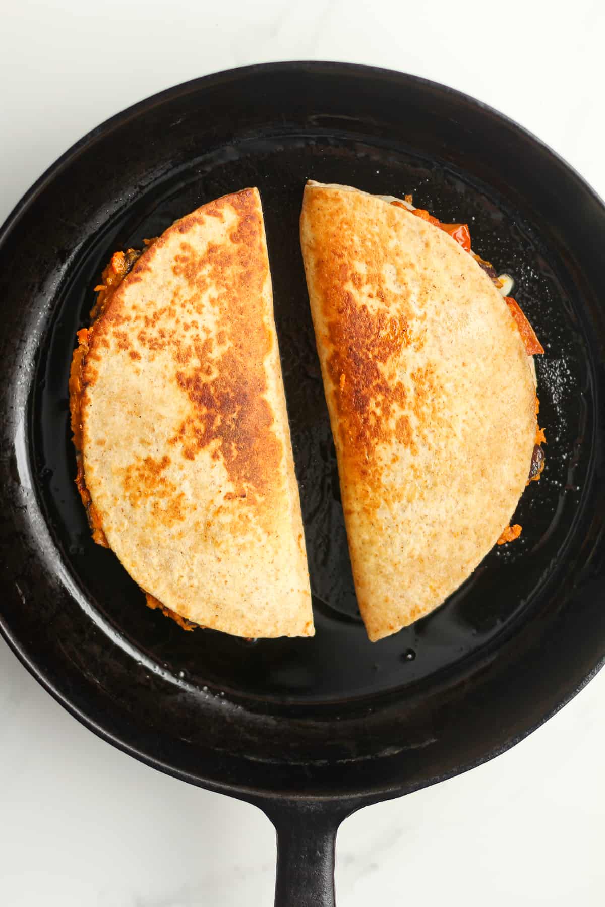 A skillet of the cooked quesadillas.