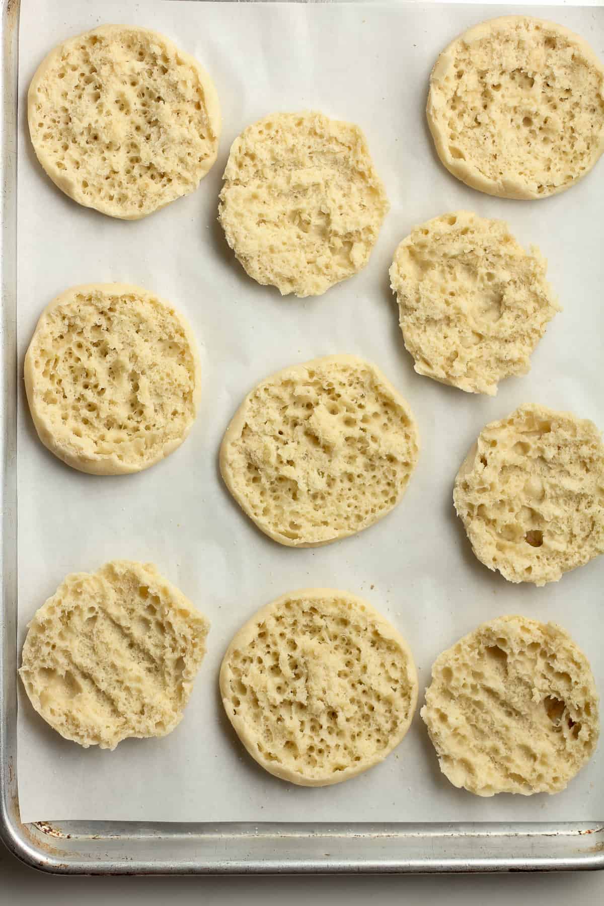 A pan of halved English muffins on a pan.