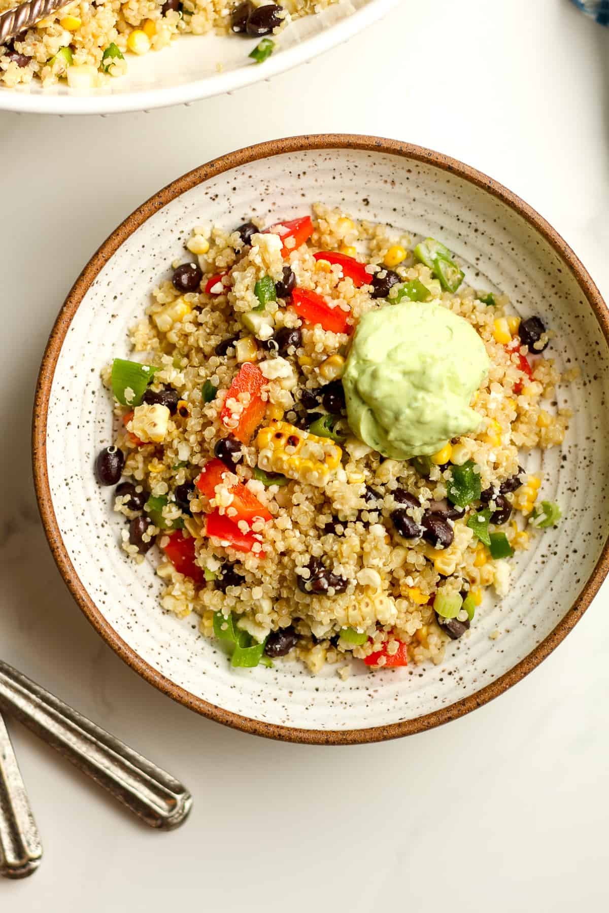 A serving of Mexican quinoa salad with a dollop of avocado crema.