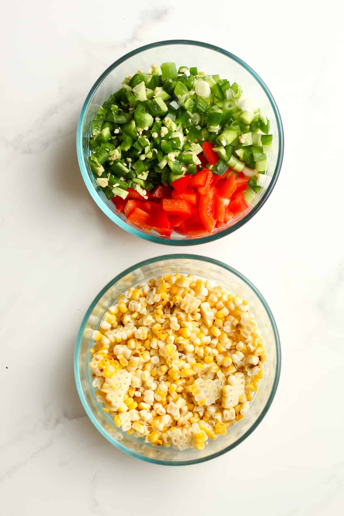 Two bowls - one with the raw veggies and another with the cooked corn kernels.