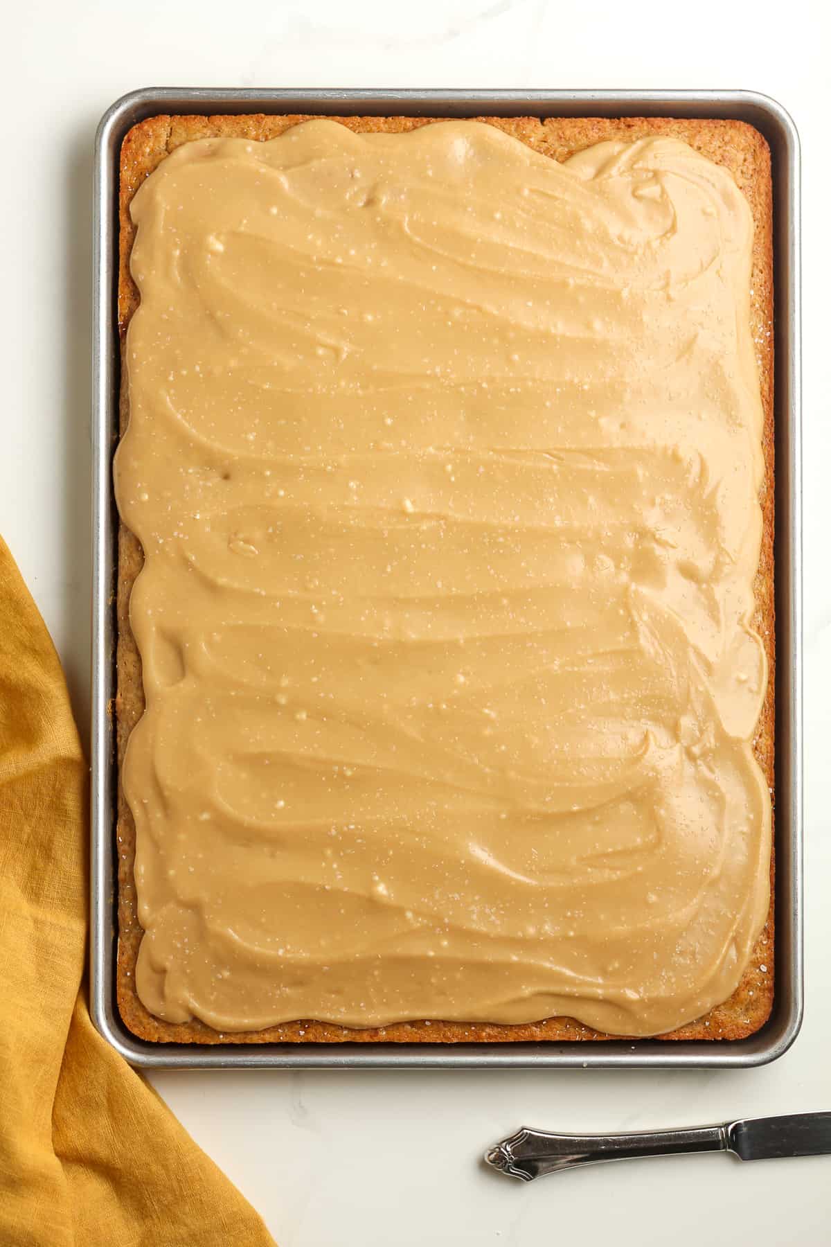 A sheet pan of the finished banana cake with caramel frosting.